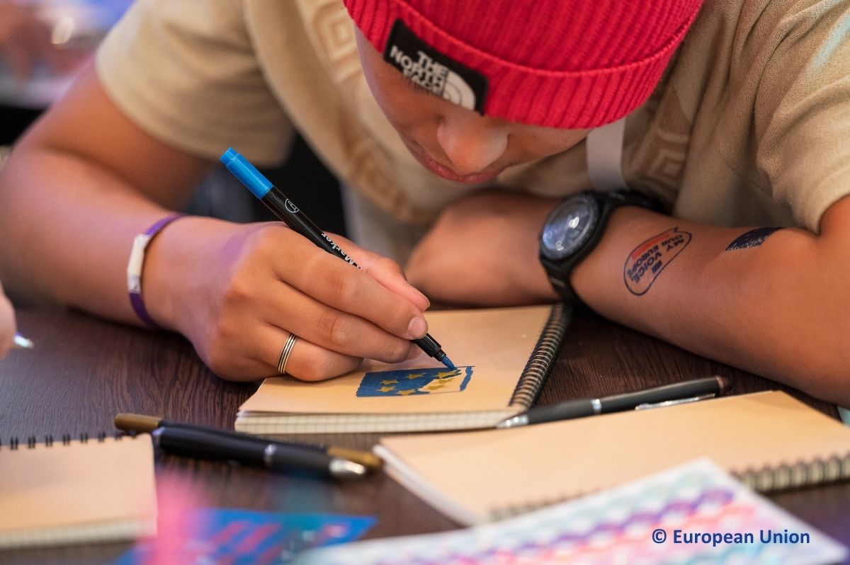 Young participant drawing in a notebook.