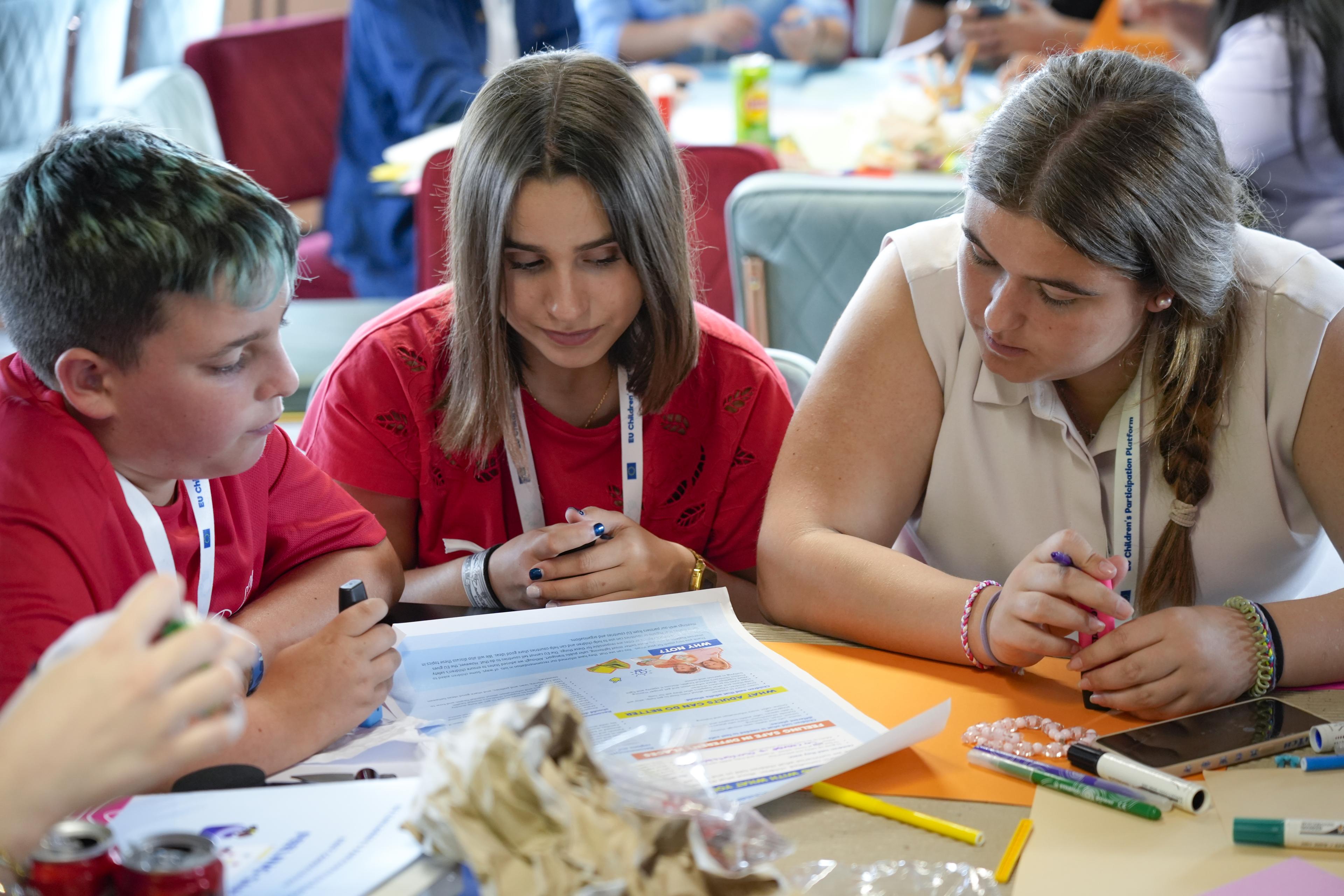 Three children reviewing a document together