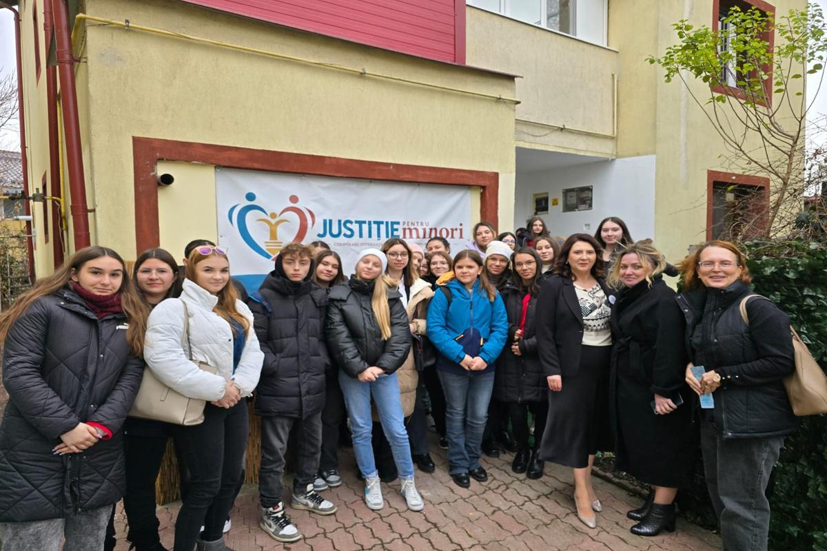 A group of adults and young people from Justice for Minors standing in front of the new centre in Romania.