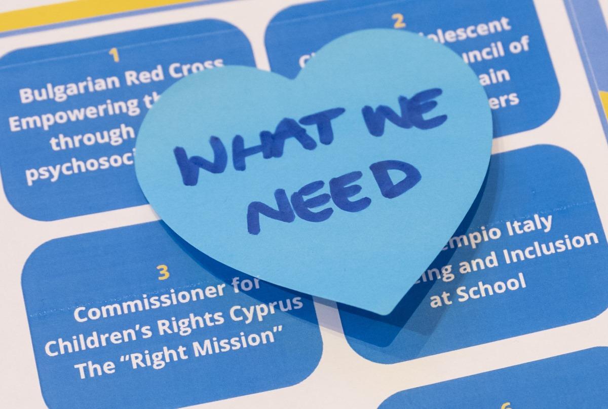 A poster showing different projects with the words what we need on a heart-shaped post-it.