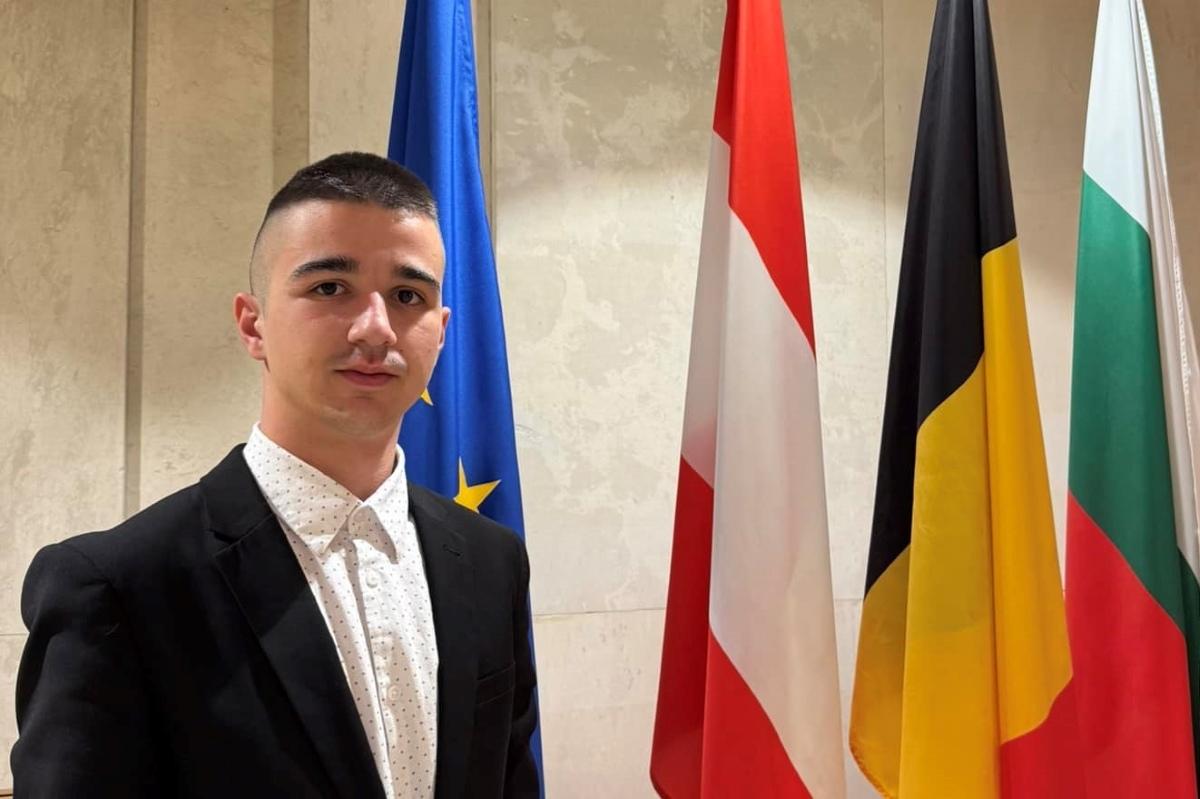 Kaloyan standing with a group of different country flags