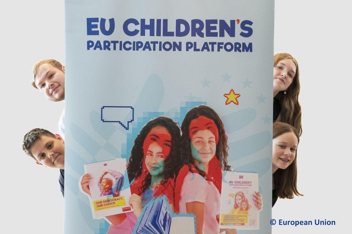 Four teens popping out from behind a big Platform poster