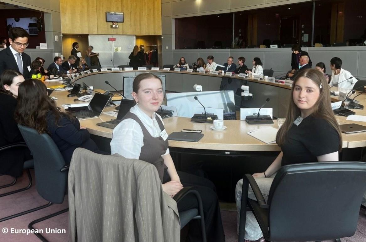 Ayata and Zuzanna sitting at big discussion panel at the European Commission