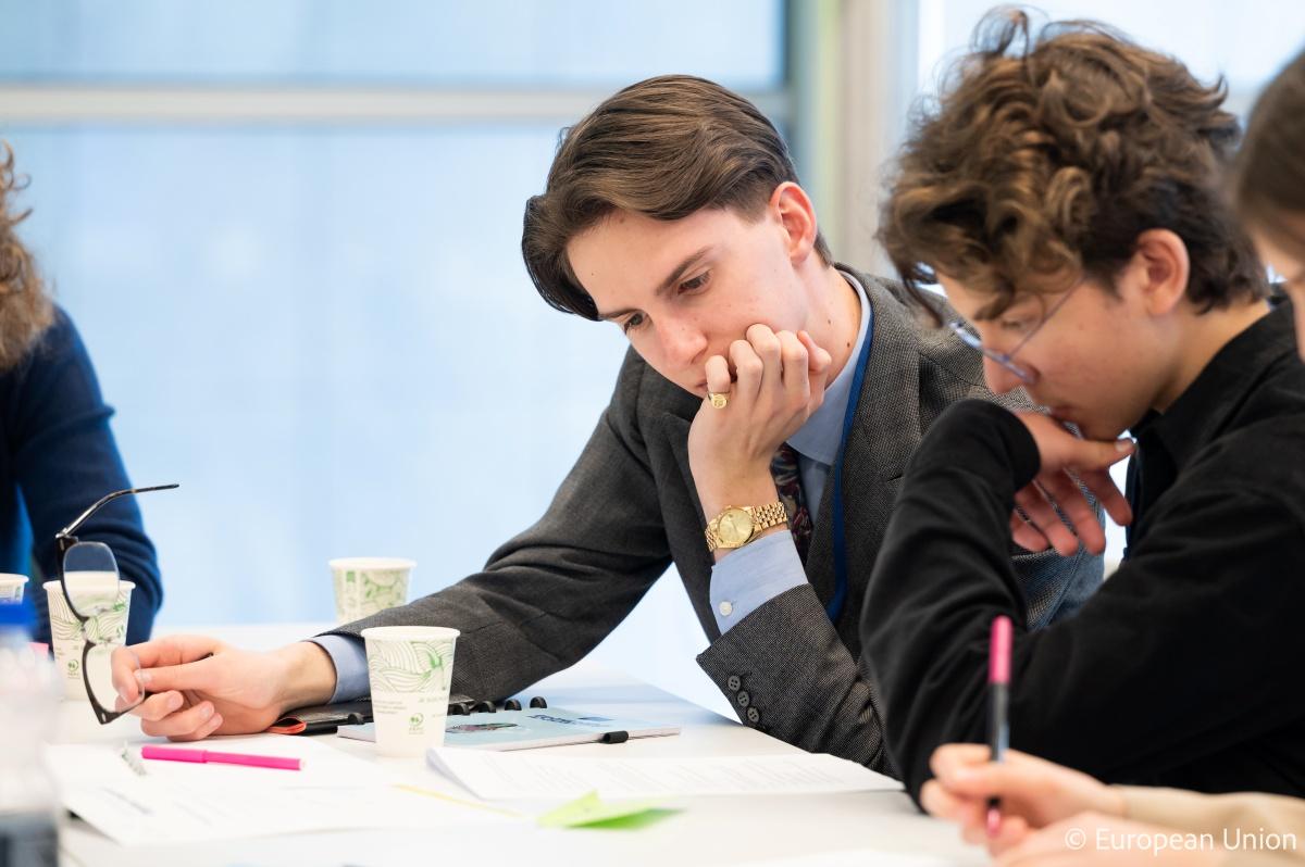Emanuele helping a young boy during a workshop