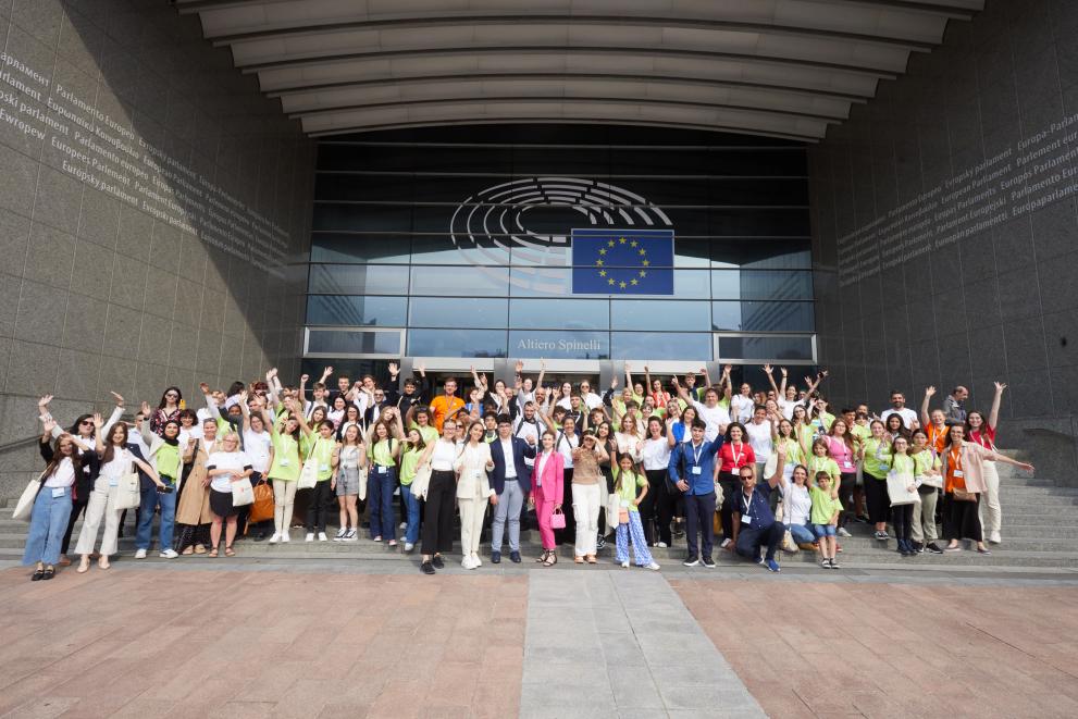 Enthusiastic group of children from diverse backgrounds at the European Parliament.