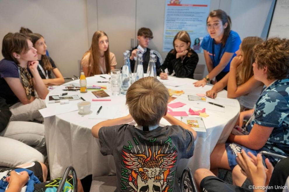 Children sitting around a table in discussion.
