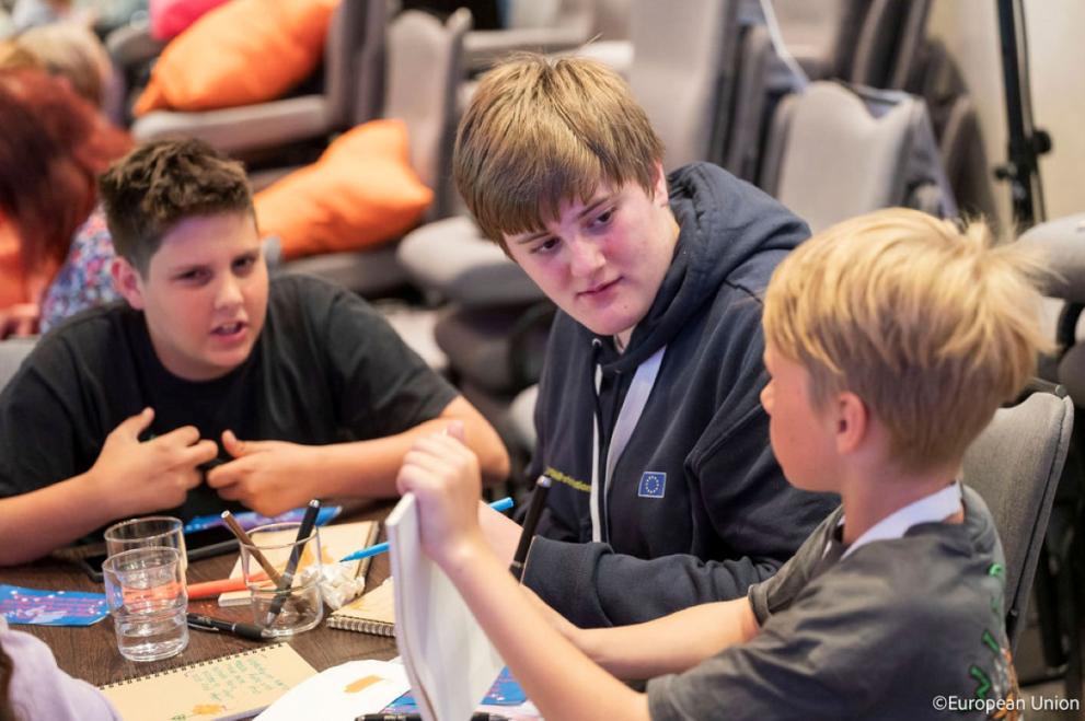 Three young boys of different ages in a serious discussion