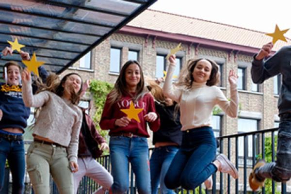 A group of happy young people with yellow EU stars